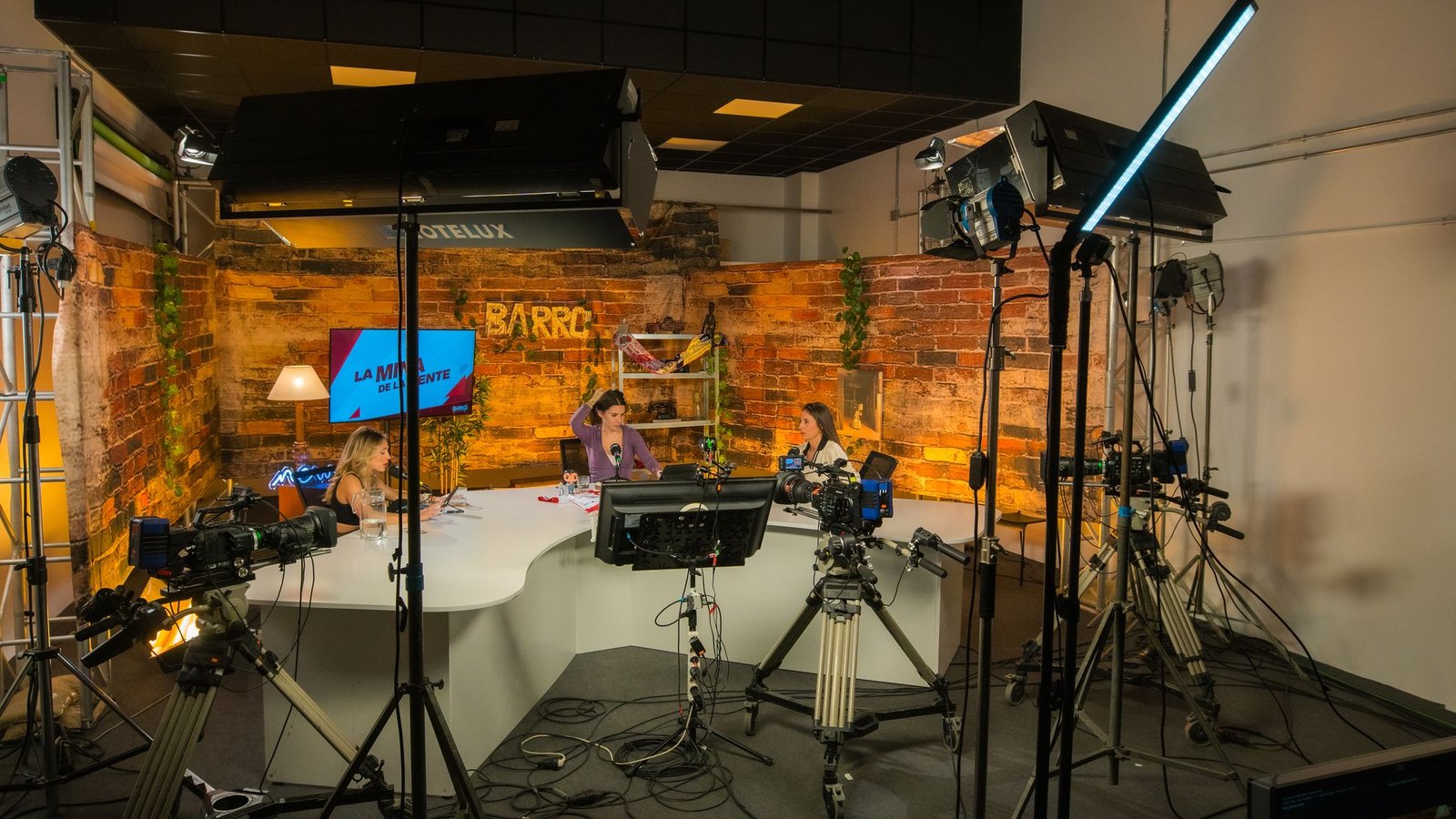 Plató profesional con cámaras, iluminación de estudio y mesa de conversación